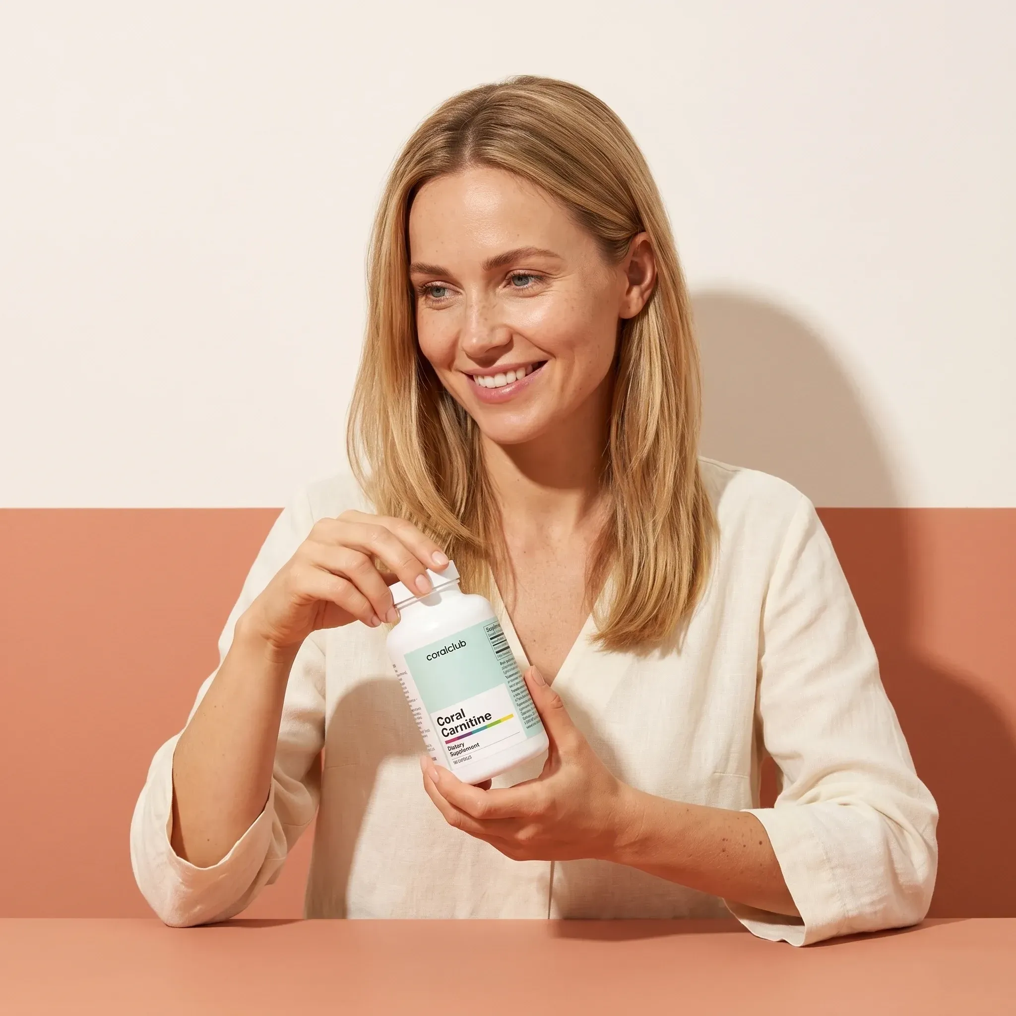 Femeie ținând flaconul Coral Carnitine într-un decor minimalist.