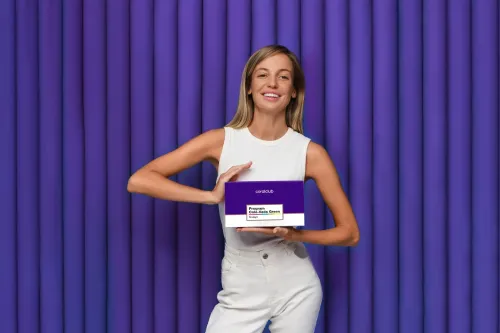 Femeie care ține cutia Program Colo-Vada Green pe fundal violet