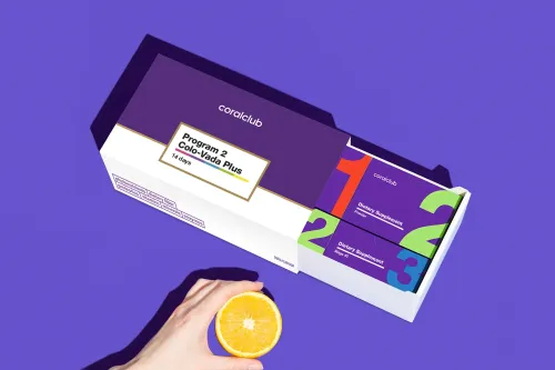 Cutia Program 2 Colo-Vada Plus deschisă, cu pliculețele numerotate pe etape, lângă o felie de portocală
