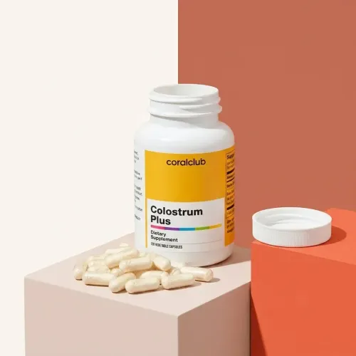 Flaconul Colostrum Plus cu capsule pe un fundal pastelat.